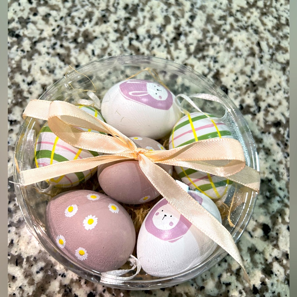 Six Easter eggs decorated in clear plastic container